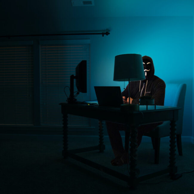 privacy hacker sitting in dark room