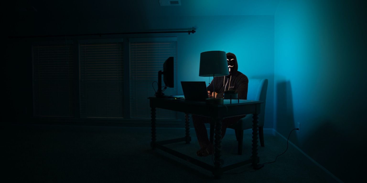 privacy hacker sitting in dark room