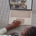 black woman in bed video chatting with her community