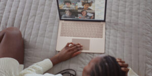 black woman in bed video chatting with her community