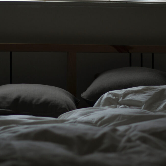 bed in dark room preparing for sleep