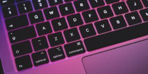 laptop keyboard with pink and purple hue