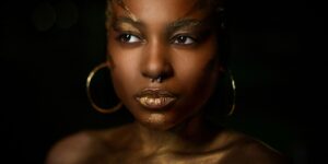 Black woman wearing gold face makeup