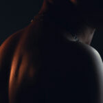 shirtless male looking through his shoulder