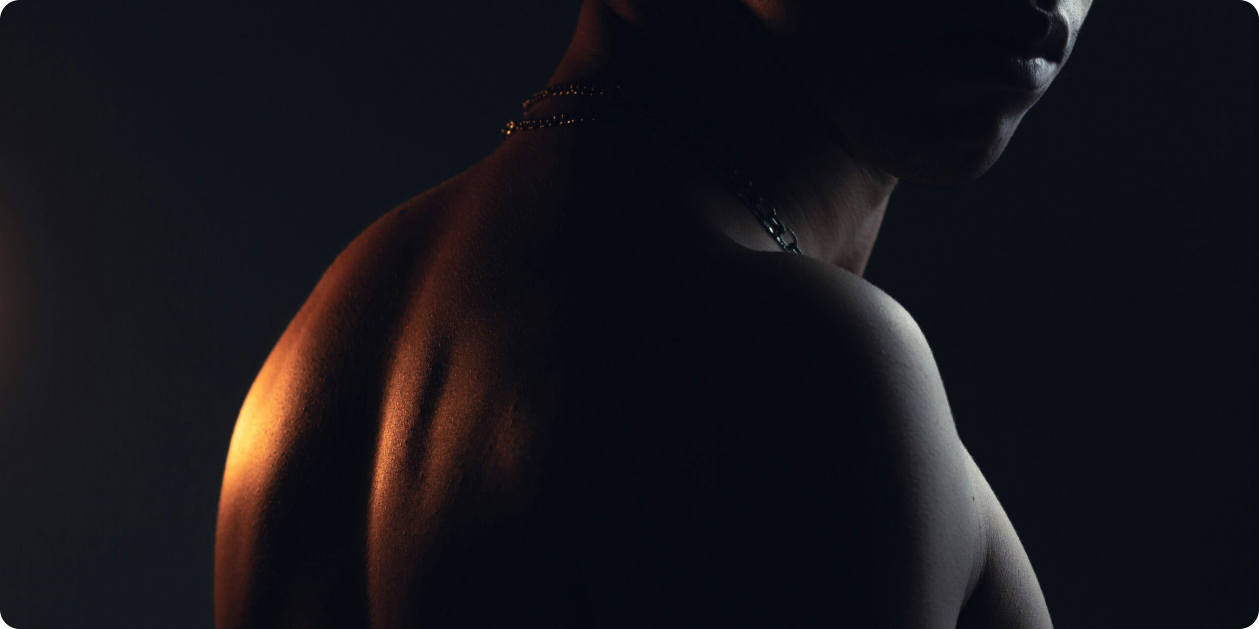 shirtless male looking through his shoulder