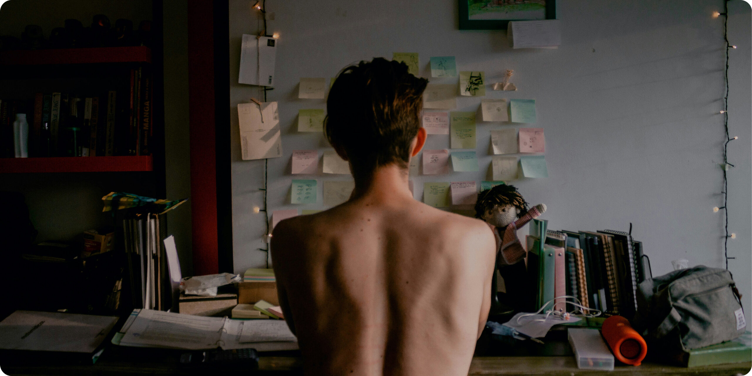 White man sitting on his desk from behind