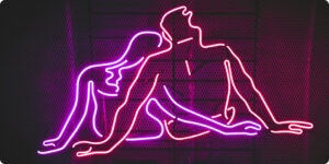 Pink and red neon light of a naked couple