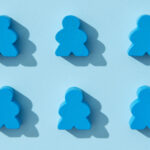 Ten blue board game pawns arranged in two rows of five on a light blue background, each casting a shadow.
