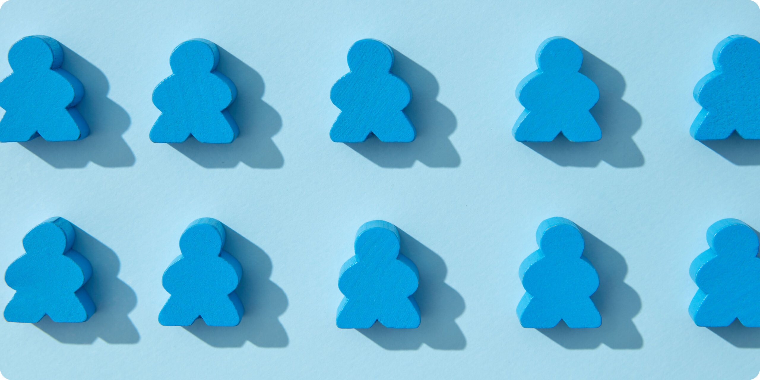 Ten blue board game pawns arranged in two rows of five on a light blue background, each casting a shadow.